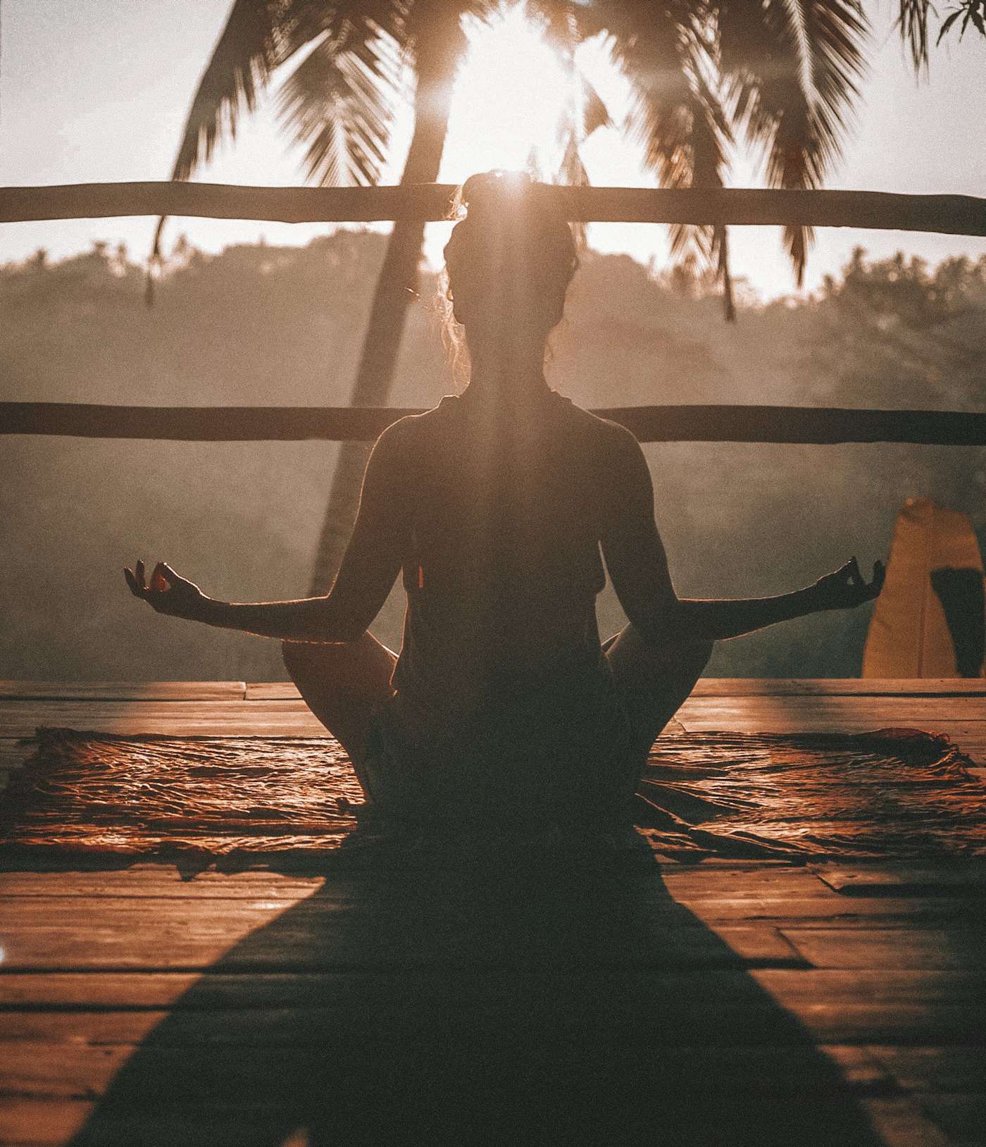 Silueta de una persona meditando al amanecer